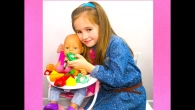 Little girl feeding her baby doll with velcro food